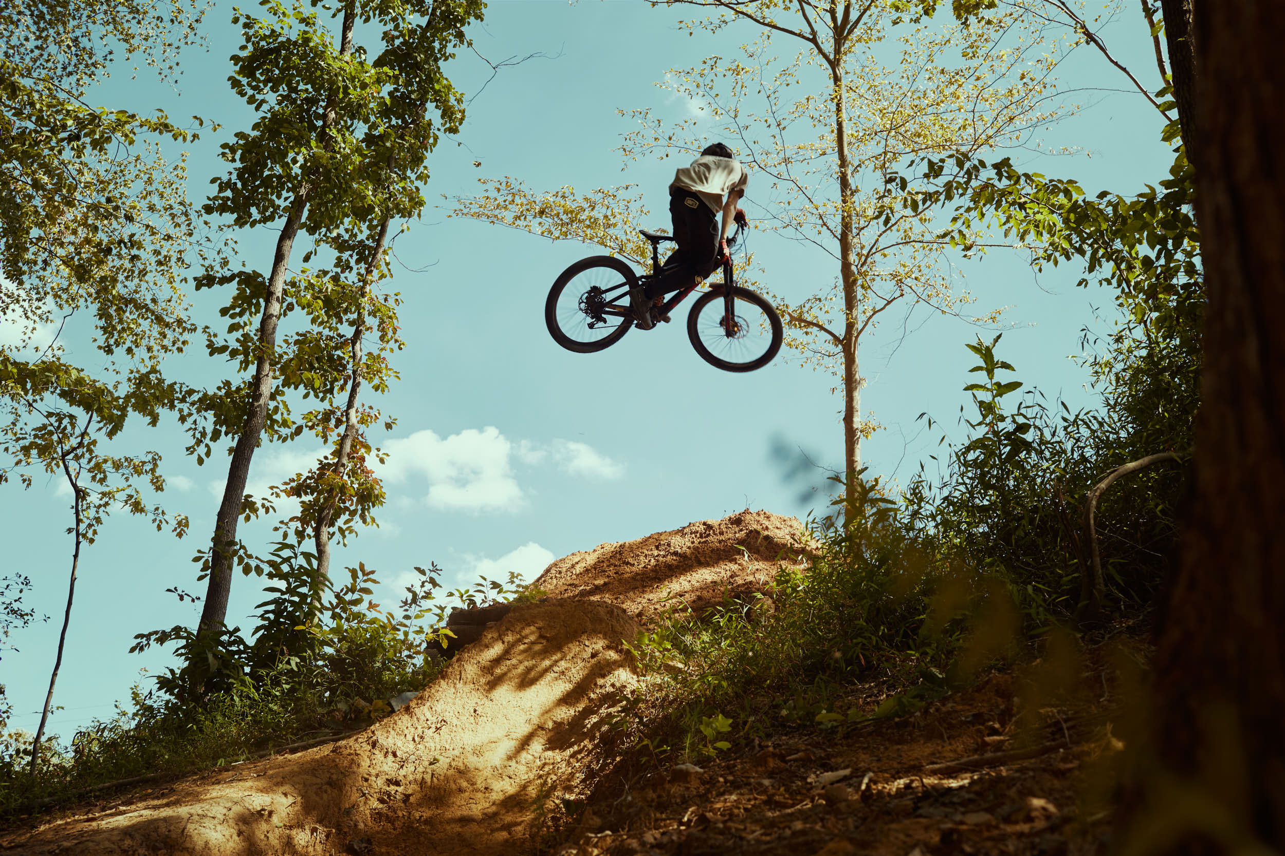 Cooper Rodrigues, downhill biker, jumping a hand-dug ramp in Raleigh, NC.