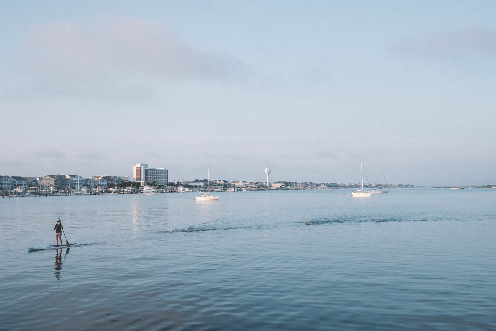 Paddleboarder and swimmers.